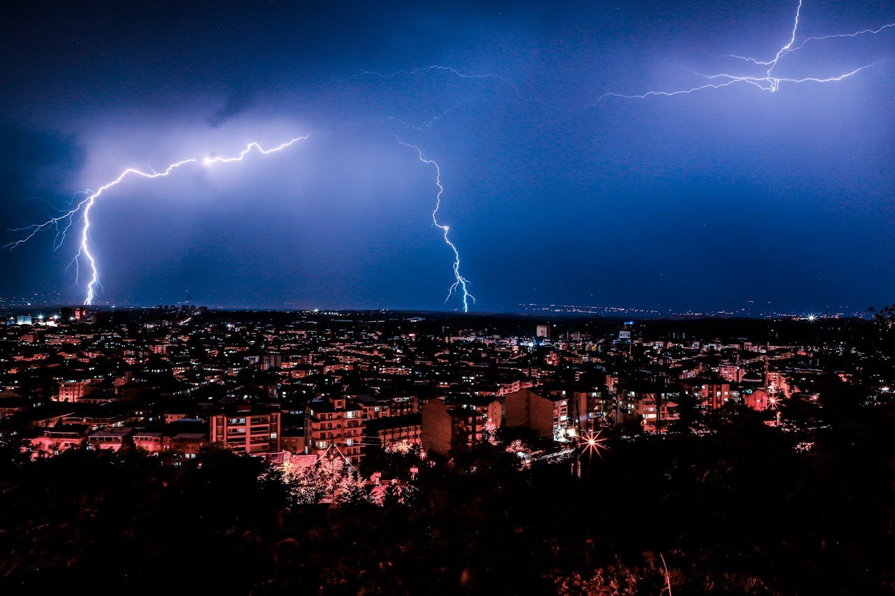 Dramatic night cityscape with vivid lightning illuminating the skyline.